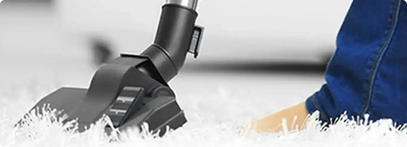 Close-up of a professional vacuuming a white carpet in Pembroke Pines.
